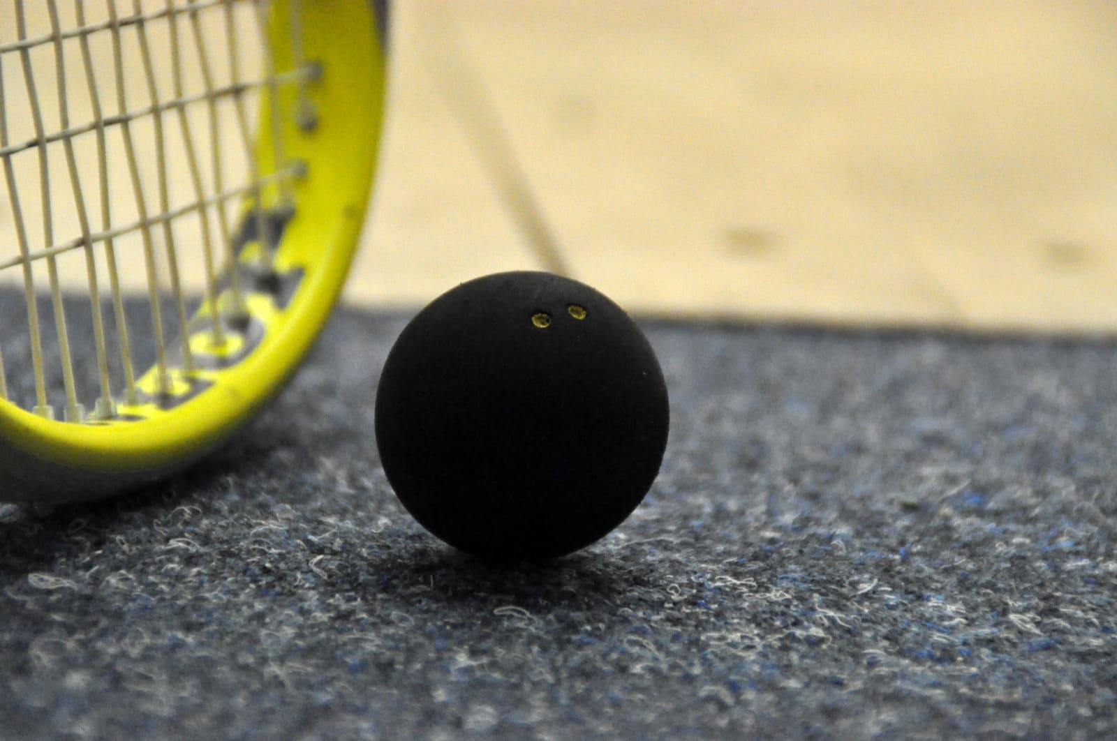 Squashball neben dem Schläger